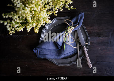 La molla messa in tavola con maggio lily on dark tavolo in legno con spazio di copia Foto Stock