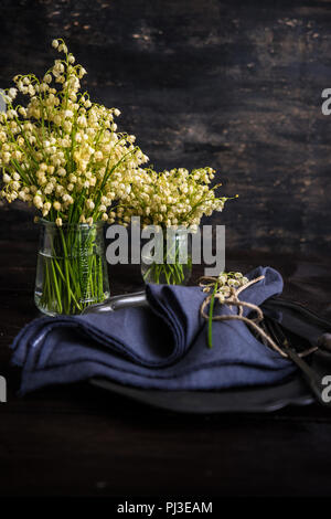 La molla messa in tavola con maggio lily on dark tavolo in legno con spazio di copia Foto Stock