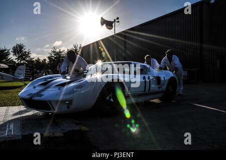 Meccanica spingendo una Ford GT40 fuori nel sole basso al Goodwood. Le Mans era sport prototipo di vettura da corsa Foto Stock