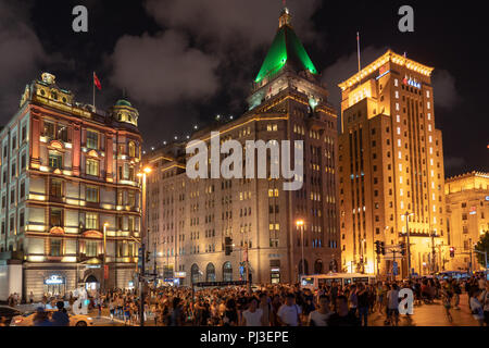 Folla enorme attraversa la strada da East Nanjing Road per la passeggiata lungo il Bund a prendere in vista della Skyline di Pudong di Shanghai, Cina. Foto Stock