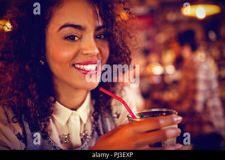 Ritratto di giovane donna con un cocktail di benvenuto Foto Stock