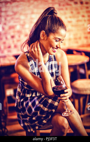 Giovane donna avente il vino rosso Foto Stock