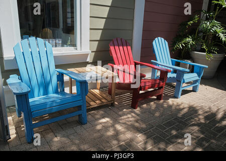 Vuoto Adirondack colorate sedie sul patio di mattoni in Florida, Stati Uniti d'America. Foto Stock