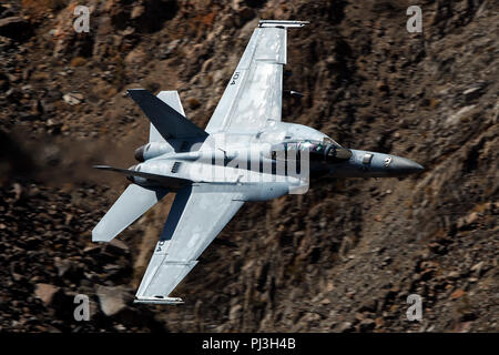 Marina degli Stati Uniti Boeing F/A-18F Super Hornet (lato 104) dal VFA-154 Cavalieri Neri squadron vola basso livello sulla transizione Jedi attraverso Star Wars Canyon / Rainbow Canyon, il Parco Nazionale della Valle della Morte, Panamint Springs, California, Stati Uniti d'America Foto Stock