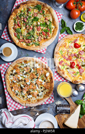 La prima colazione gourmet pizza con uova, prosciutto e lox sul tavolo vista aerea Foto Stock