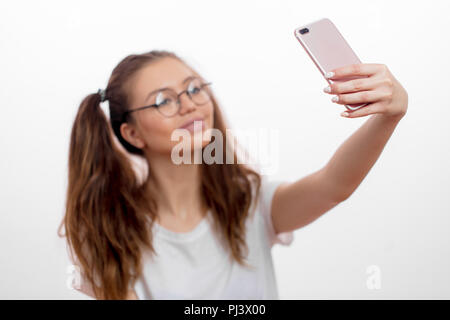 Focus su smart phone che viene utilizzato per prendere un selfie da adorabile ragazza Foto Stock