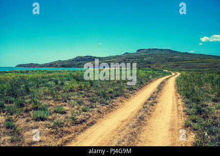 Strada sterrata attraverso la steppa al mare. La bellissima natura Foto Stock