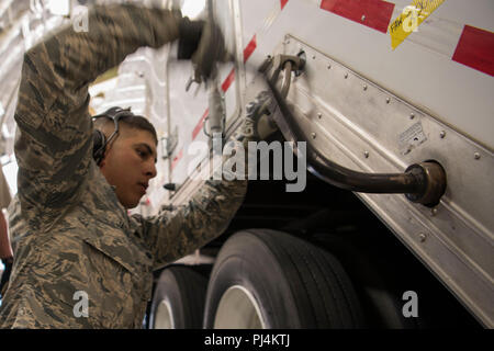 Airman 1. Classe Giovanni Jaquez, supporto di comunicazioni il terminale operatore con la quarta operazioni nello spazio Squadron, gira a leva per fissare un comando mobile e il sistema di controllo in luogo durante la quarta POS mobile di distribuzione presso la Base Aerea Peterson, Colorado, Agosto 27, 2018. Il MCC è fissata in modo sicuro con le catene e il supporto in legno pilastri per il volo. (U.S. Air Force foto di Airman 1. Classe William Tracy) Foto Stock