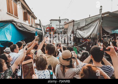 Bangkok, Tailandia - 27 Gennaio 2018: Turisti in attesa per il treno e fotografie di Maeklong ferrovia via mercato (mercato del treno). Foto Stock