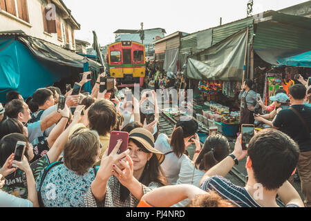 Bangkok, Tailandia - 27 Gennaio 2018: Turisti in attesa per il treno e fotografie di Maeklong ferrovia via mercato (mercato del treno). Foto Stock