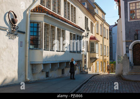 Tallinn street, vista di due metà di età compresa tra i turisti in piedi al di fuori della farmacia più antica d'Europa - la Apteek (1422) nella città vecchia di Tallinn, Estonia. Foto Stock