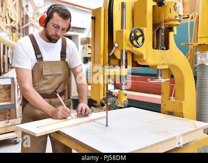 Carpenter lavora in una falegnameria - officina per la lavorazione del legno e di sezionatura Foto Stock