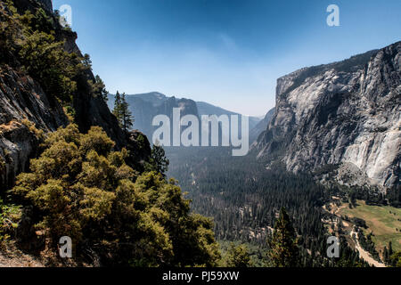 Una vista guardando verso il Parco Nazionale di Yosemite Valley con El Capitan sulla destra nel Parco Nazionale di Yosemite. Il fumo proveniente da incendi indugia nella valle. Foto Stock