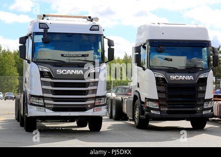 Due di nuova generazione Scania camion, R650 griglia grigia, R730 griglia nera, sul cantiere. Riflessioni di Scania logo. Seinäjoki, Finlandia - 11 agosto 2018. Foto Stock