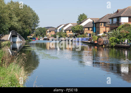 Vista dalla strada alzaia guardando a nord lungo il Grand Union Canal. Attraenti case moderne linea il lungomare. Harefield, Middlesex, England, Regno Unito Foto Stock