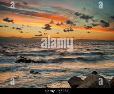 Rompere le nuvole formano un disegno casuale al tramonto sulla spiaggia di Rossall Foto Stock