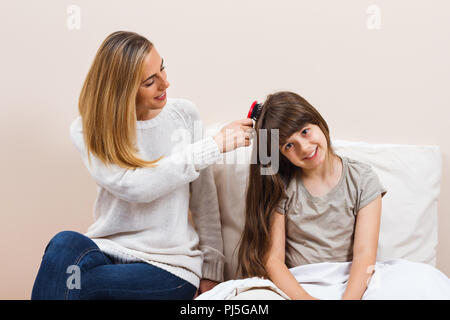 Prendersi cura della figlia di capelli Foto Stock