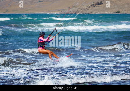 Atleta uomo una donna kitesurfer facendo kitesurf trucchi e salti Foto Stock