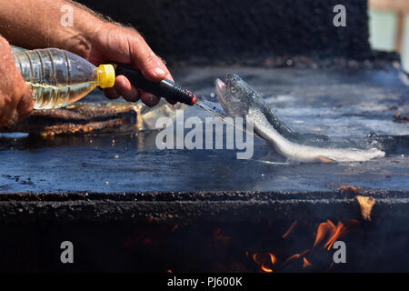 Cucinare il pesce alla griglia su Vama Veche beach, non mainstream di destinazione turistica sulla costa del Mar Nero,destinazione popolare per i turisti provenienti da tutto il mondo Foto Stock