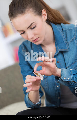 Giovane donna bella sigaretta di laminazione Foto Stock