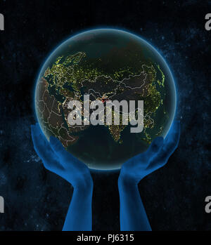 Tagikistan nella notte il pianeta Terra con visibili i confini del paese in mani nello spazio. 3D'illustrazione. Foto Stock