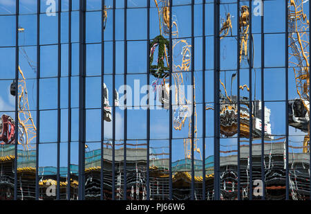 Berlino, Germania. 04 Sep, 2018. 04.09.2018, Berlin: durante il topping-out cerimonia di Axel Springer nuovo edificio, il topping-out corona e gru edili sono riflesse nella facciata di vetro della casa editrice in Kochstraße. Credito: Soeren Stache/dpa/Alamy Live News Foto Stock