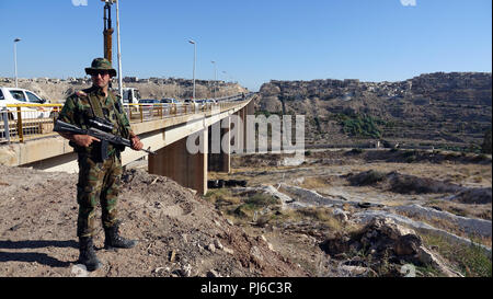 Rastan, Siria. Il 15 agosto, 2018. 15.08.2018, Siria, Rastan: un soldato siriano sta al strategicamente importante ponte di Rastan sull'autostrada 5 Damascus-Aleppo. (A DPA-storia Siria - paese distrutto dal 05.09.2018) Credito: Friedemann Kohler/dpa/Alamy Live News Foto Stock