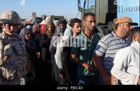 Rastan, Siria. Il 15 agosto, 2018. 15.08.2018, Siria, Rastan: Siri stand in linea per il russo aiuti alimentari. (A DPA-storia Siria - paese distrutto dal 05.09.2018) Credito: Friedemann Kohler/dpa/Alamy Live News Foto Stock