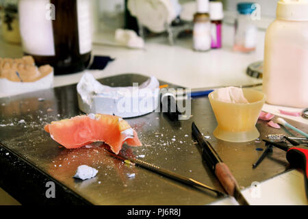 Processo per la fabbricazione di acido acrilico odontotecnico. Protesi dentale, dentiere, protesi di lavoro. Odontotecnico nel processo di realizzazione di protesi. Processo. Foto Stock