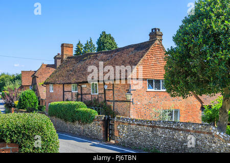 Strada graziosa chiesa di mattoni rossi Cottage con pietra focaia giardino parete in East Clandon, un piccolo villaggio nel Surrey vicino a Guildford, sud-est Inghilterra Foto Stock