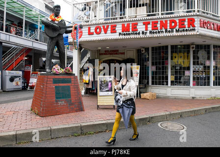Una donna cammina davanti ad una statua di Elvis Presley in Tokyo giovedì 16 agosto 2007, sotto la quale sono stati stabiliti i grappoli di fiori per commemorare gio Foto Stock