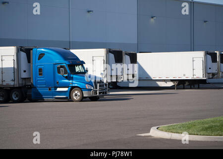 Un numero enorme di big rig semi camion vengono caricate e scaricate nei bacini dei grandi magazzini, si stacca semirimorchi, fissaggio già caricato, Foto Stock