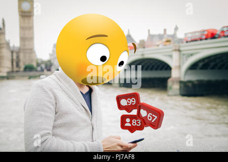 Uomo con testa emoji sorpreso guardando lo smartphone al London City Foto Stock