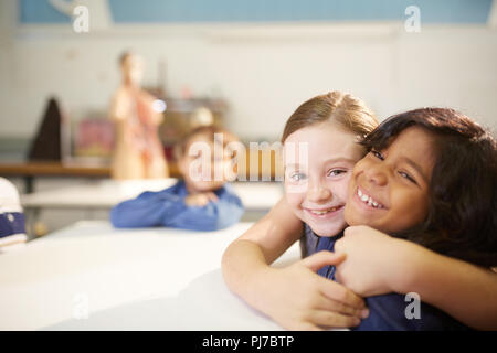 Ritratto affettuoso, carino studentesse avvolgente Foto Stock