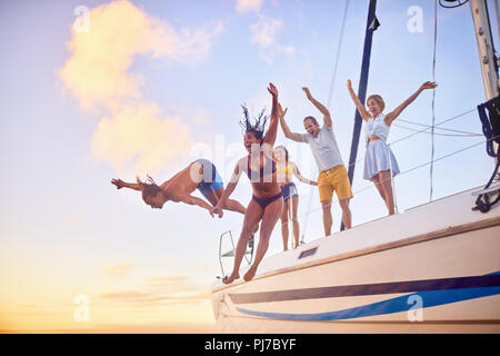 Giocoso amici salta fuori da barca Foto Stock