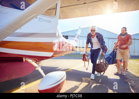 Gli uomini con i sacchetti di imbarco aereo di piccole dimensioni Foto Stock