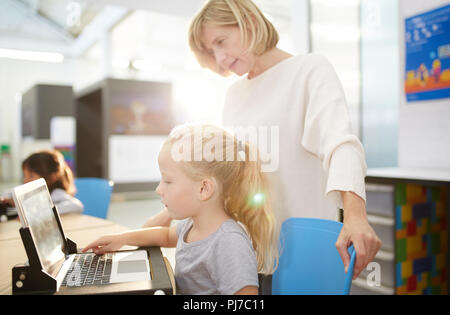 Insegnante e schoolgirl utilizzando laptop in science center Foto Stock