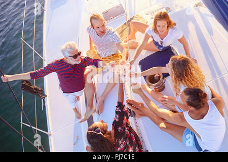 Vista da sopra gli amici tostare champagne sulla barca di sole Foto Stock