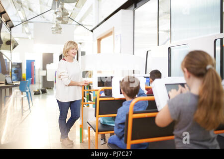 L insegnante e gli studenti usando il touch screen computer Foto Stock