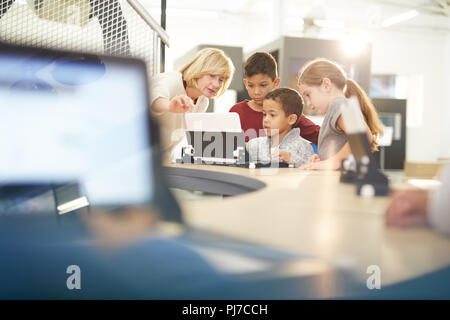 L insegnante e gli studenti usando computer portatile Foto Stock