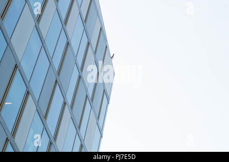 Architettura minimalista che punta verso il luminoso cielo soleggiato con linee geommetrical e windows Foto Stock