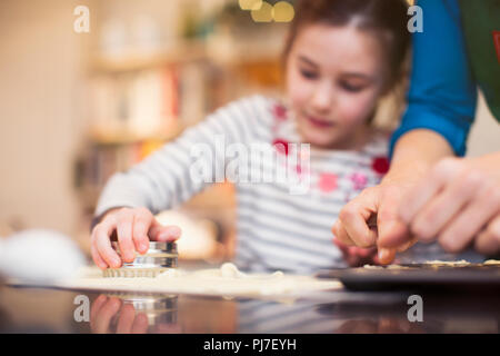 Madre e figlia la cottura, utilizzando cookie cutter Foto Stock