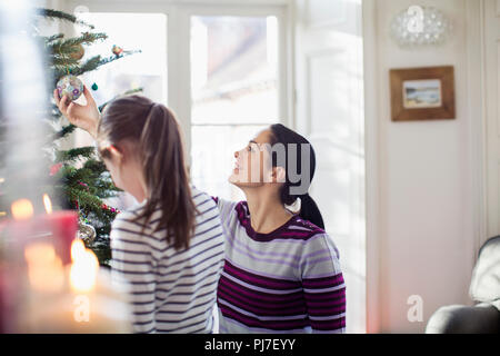 Madre e figlia decorare albero di Natale Foto Stock