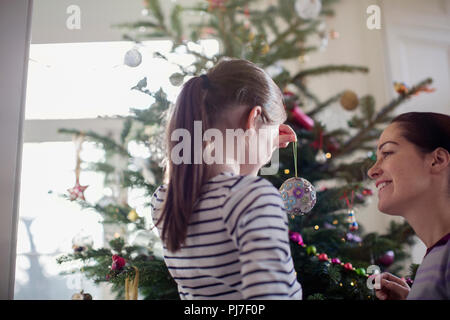 Madre e figlia decorare albero di Natale Foto Stock