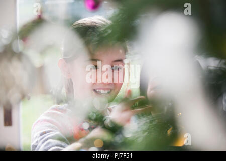 Ragazza sorridente decorare albero di Natale Foto Stock