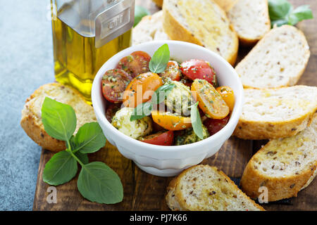 Caprese bruschetta con pomodori ciliegia, mozzarella e pesto di basilico Foto Stock