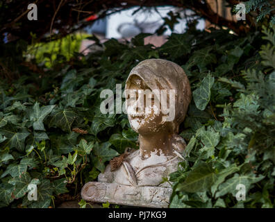 Donna faccia antica statua busto in giardino Foto Stock