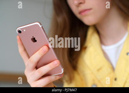 Teen tiene iphone 7 utilizzando i social media Foto Stock