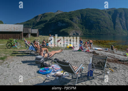 Norvegia, luglio 26, 2018: la gente a prendere il sole su una spiaggia del fiordo su un caldo giorno d'estate. Foto Stock