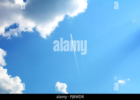 Tracciato dal piano sullo sfondo del cielo blu con nuvole cumulus Foto Stock